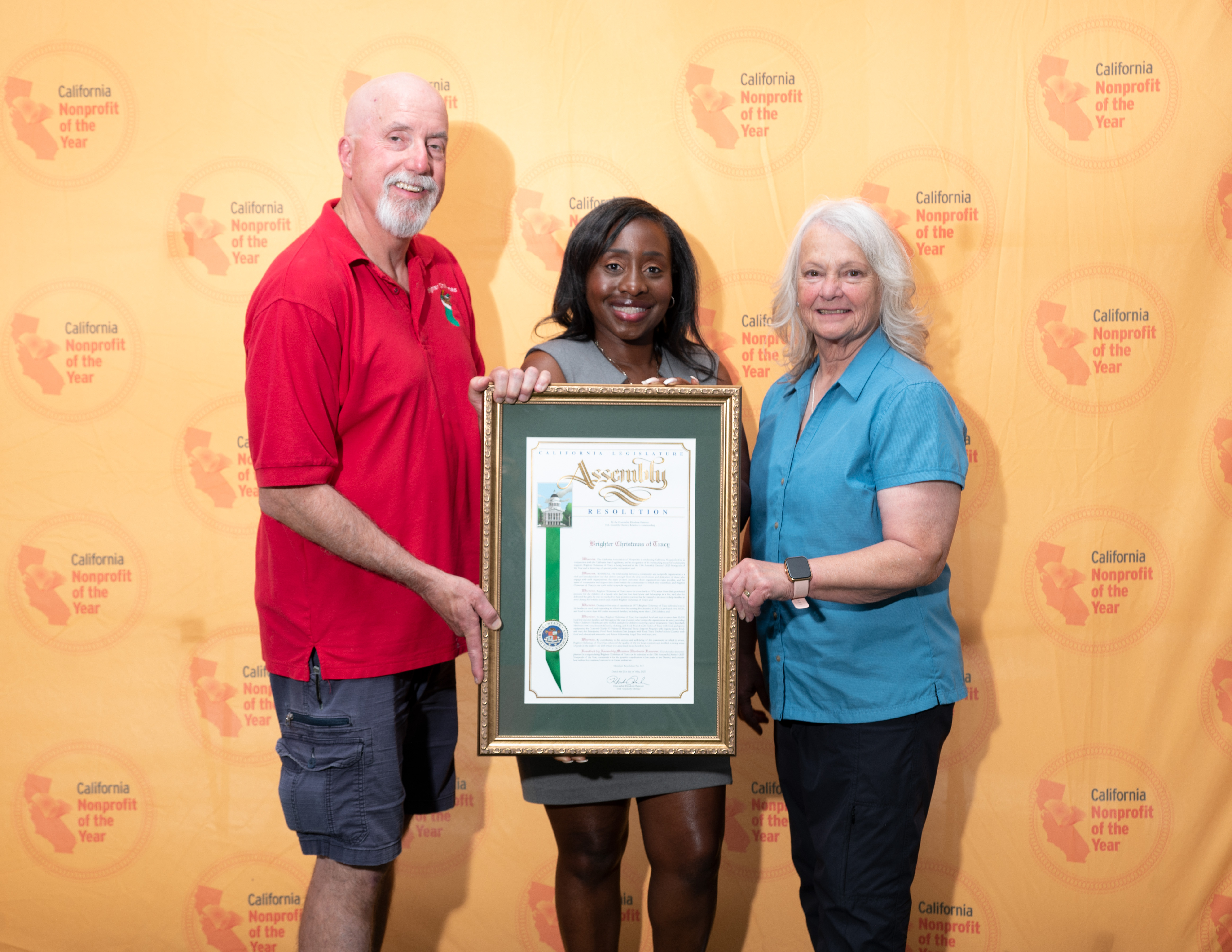 Assemblymember Rhodesia Ransom presents a California State Assembly Resolution to Brighter Christmas Chair Steve Abercombie and Board Member Lori Sparger during the 2025 California Nonprofit of the Year Reception at the State Capitol.