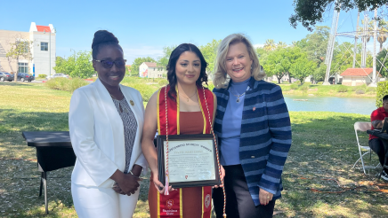 Assemblymember Rhodesia Ransom, and Stanislaus State President, Britt Rios-Ellis, with graduating student