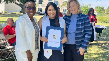 Assemblymember Rhodesia Ransom, and Stanislaus State President, Britt Rios-Ellis, with graduating student