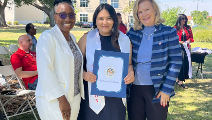 Assemblymember Rhodesia Ransom, and Stanislaus State President, Britt Rios-Ellis, with graduating student