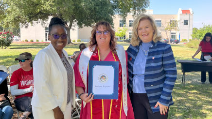 Assemblymember Rhodesia Ransom, and Stanislaus State President, Britt Rios-Ellis, with graduating student