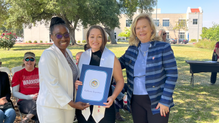 Assemblymember Rhodesia Ransom, and Stanislaus State President, Britt Rios-Ellis, with graduating student