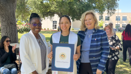 Assemblymember Rhodesia Ransom, and Stanislaus State President, Britt Rios-Ellis, with graduating student
