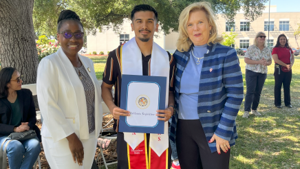 Assemblymember Rhodesia Ransom, and Stanislaus State President, Britt Rios-Ellis, with graduating student