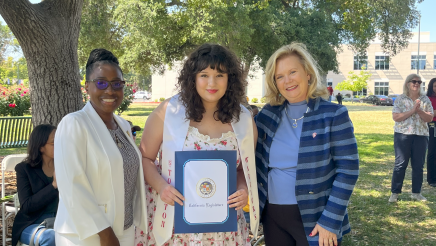 Assemblymember Rhodesia Ransom, and Stanislaus State President, Britt Rios-Ellis, with graduating student