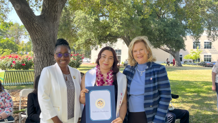 Assemblymember Rhodesia Ransom, and Stanislaus State President, Britt Rios-Ellis, with graduating student