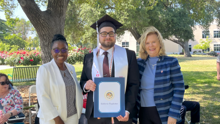 Assemblymember Rhodesia Ransom, and Stanislaus State President, Britt Rios-Ellis, with graduating student