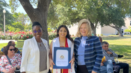 Assemblymember Rhodesia Ransom, and Stanislaus State President, Britt Rios-Ellis, with graduating student